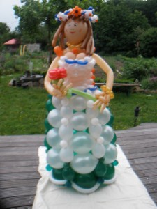 Eine Frau in Kleid und Schürze Haarkranz mit Blumen aus Luftballons